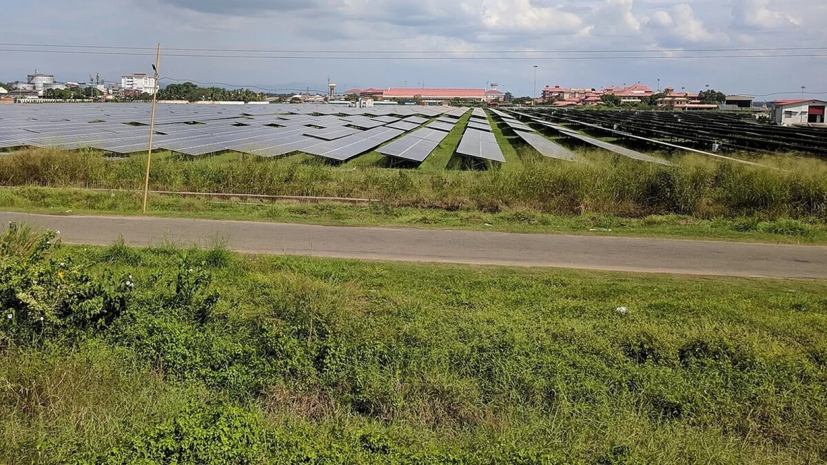 Parc fotovoltaic întins lângă un aeroport, cu șiruri de panouri pe iarbă (fotografie de arhivă de la alt aeroport, din India, imagine ilustrativă)