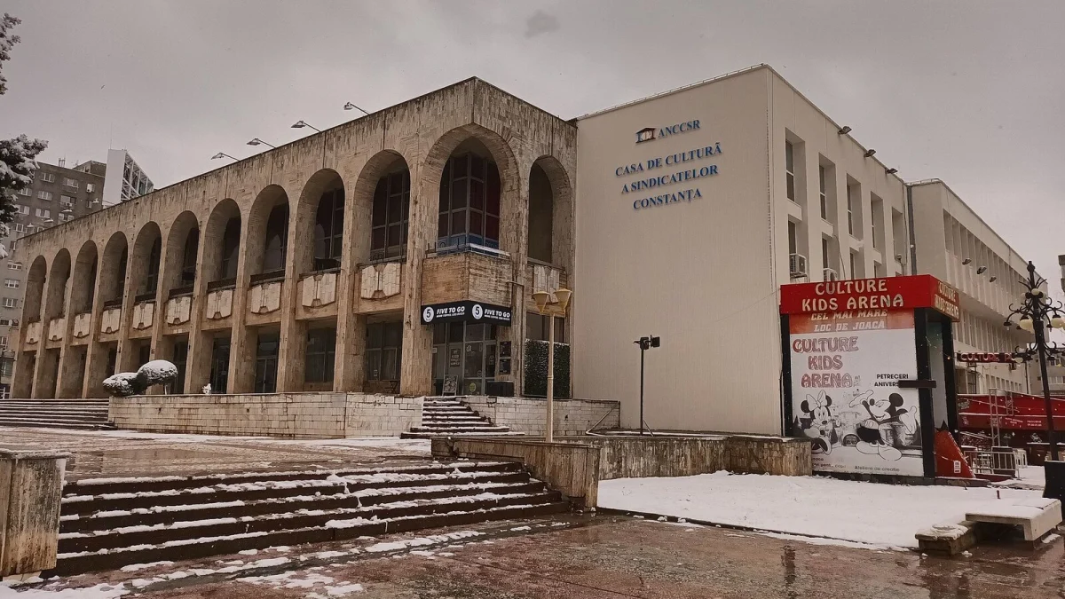 Clădirea Casei de Cultură a Sindicatelor din Constanța, cu fațada cu arcade și inscripția pe zidul alb, într-o zi de iarnă cu zăpadă (fotografie de arhivă, ianuarie 2024)