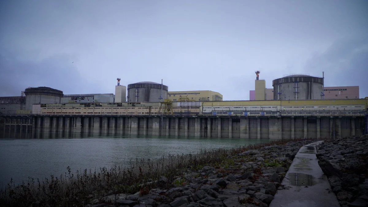 Centrala nucleară de la Cernavodă, cu clădirile reactoarelor, văzută de pe malul canalului de apă, pe cer înnorat (fotografie de arhivă, decembrie 2024)