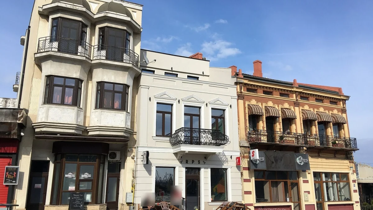 Clădiri istorice din centrul Constanței, cu balcoane din fier forjat, parter cu cafenele și cer senin (fotografie de arhivă, 2019, imagine ilustrativă)