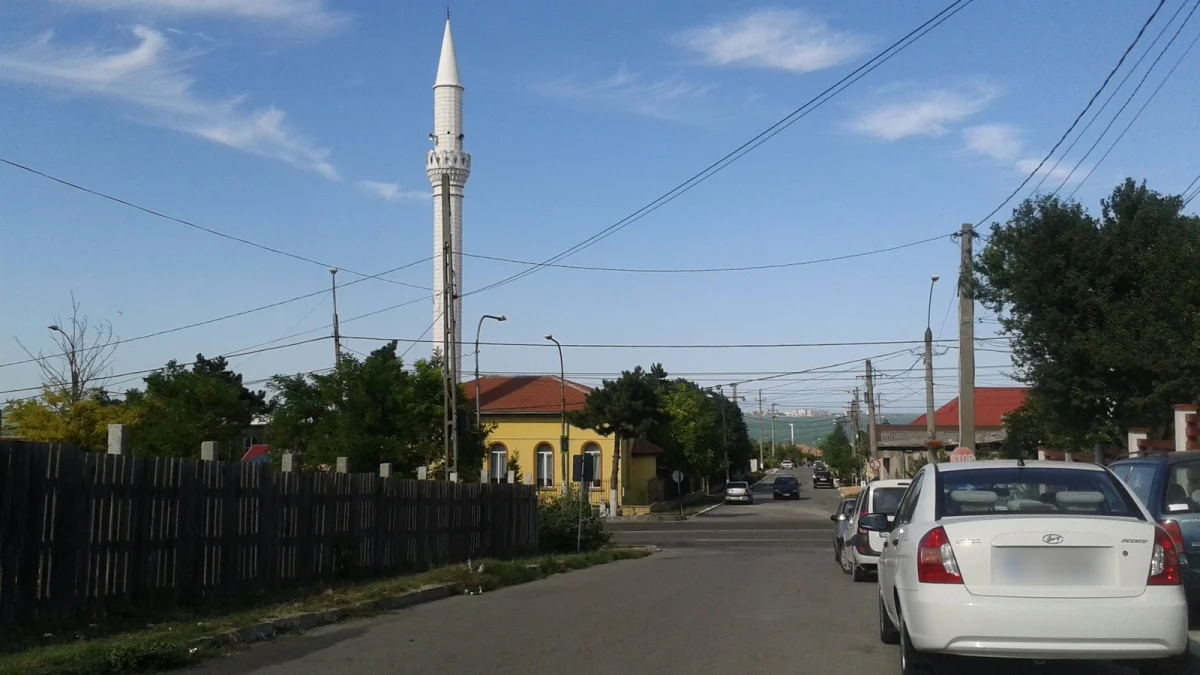 Stradă din cartierul Palazu Mare din Constanța, cu minaretul geamiei, o casă galbenă și mașini parcate (fotografie de arhivă, 2015)