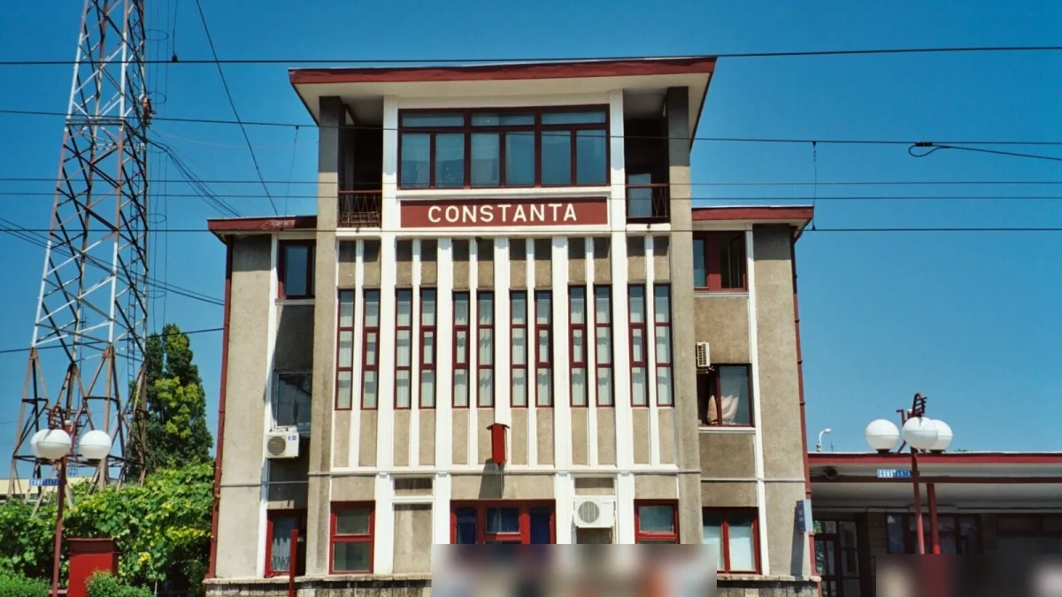 Clădirea Gării Constanța, cu inscripția „Constanta” pe fațadă și câțiva călători în față (fotografie de arhivă, 2006)
