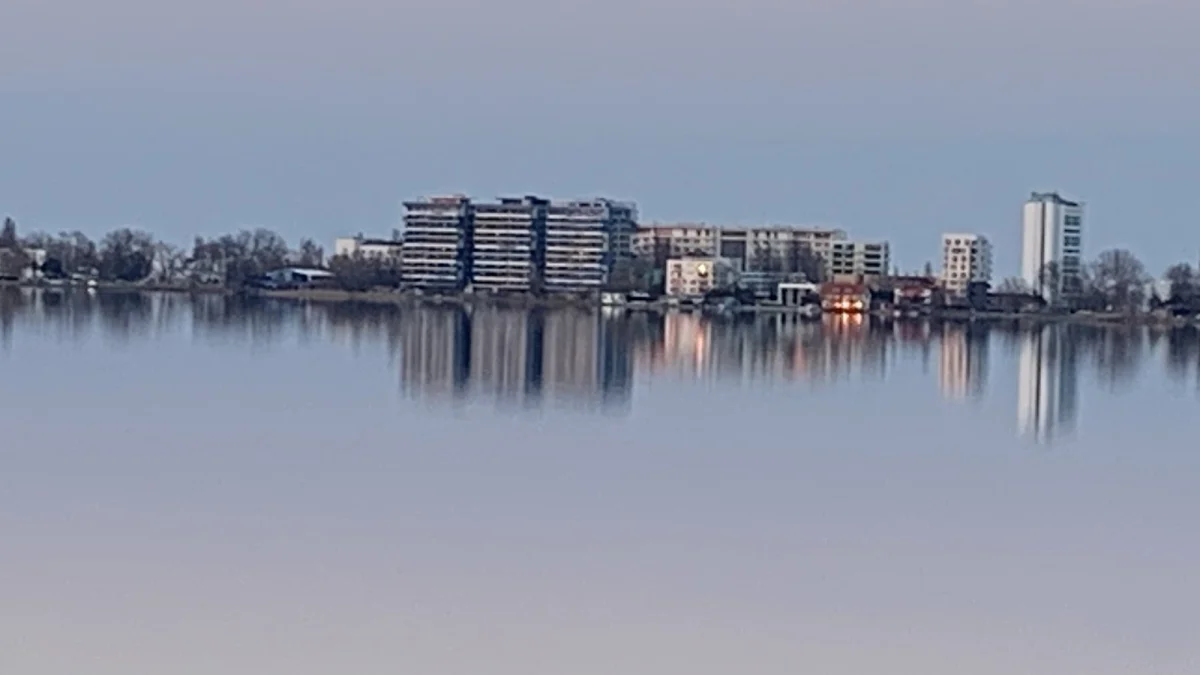 Blocuri de locuințe din stațiunea Mamaia, văzute peste lacul Siutghiol, reflectate în apă (fotografie de arhivă, imagine ilustrativă)