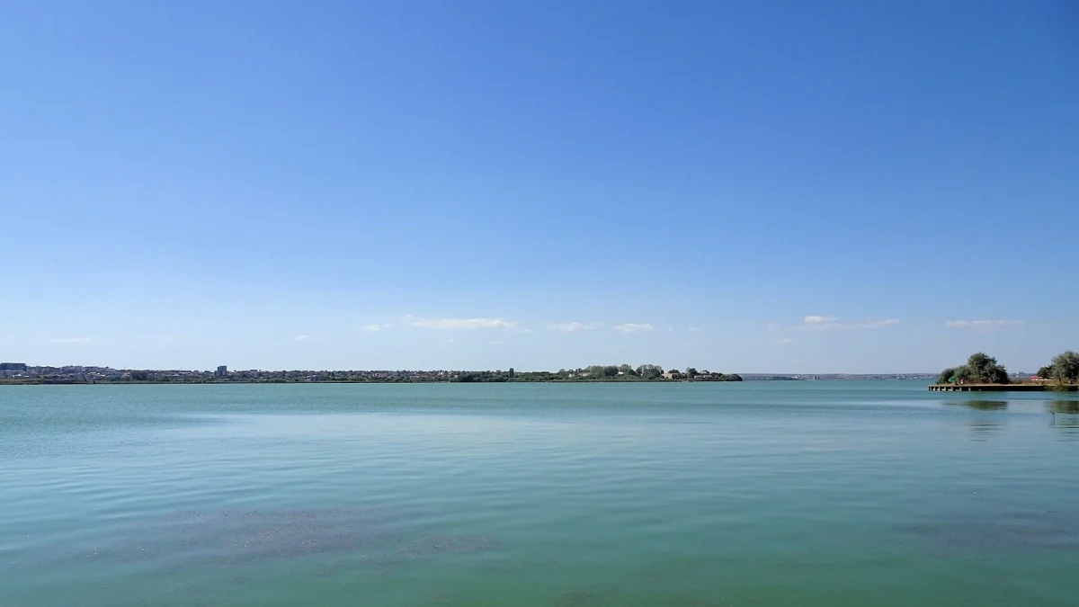 Lacul Siutghiol din Mamaia, cu apă liniștită și malul opus spre Năvodari, sub cer senin (fotografie de arhivă, 2016, imagine ilustrativă)