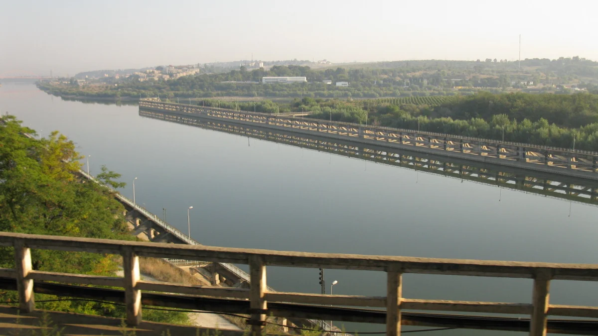 Canalul Dunăre–Marea Neagră la Cernavodă, cu digul lung care separă canalul și orașul pe dealuri în fundal (fotografie de arhivă)