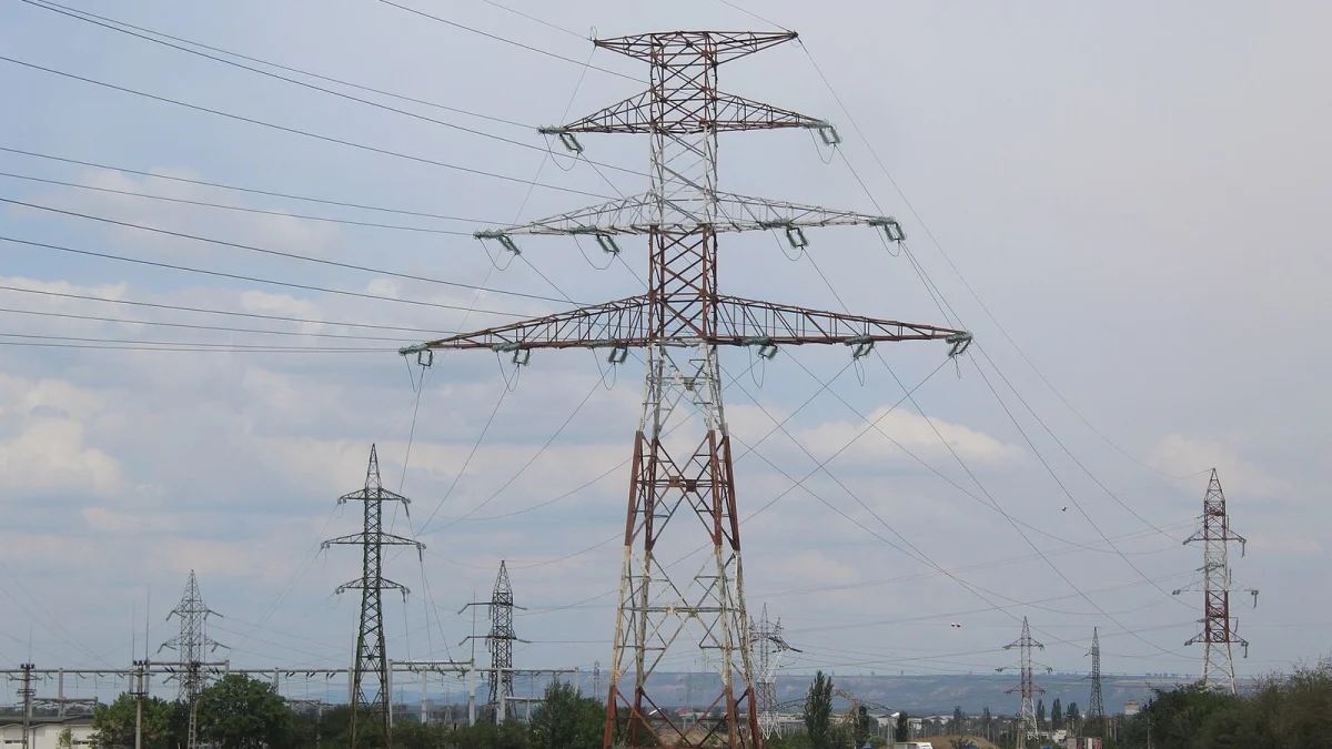 Stâlp metalic al unei linii electrice de înaltă tensiune, cu o stație de transformare în fundal (imagine ilustrativă, nu este din județul Constanța)