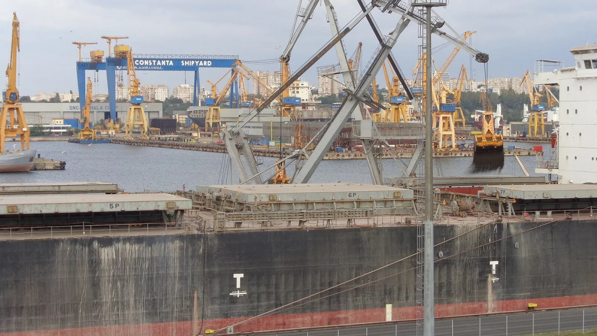 Cargou la chei în Portul Constanța, cu macarale galbene și portalul șantierului naval în fundal (fotografie de arhivă, 2014)