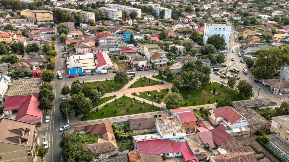 Vedere aeriană asupra unui cartier din Medgidia, cu un scuar verde, case cu acoperișuri roșii și blocuri în fundal (fotografie de arhivă, 2021, imagine ilustrativă)