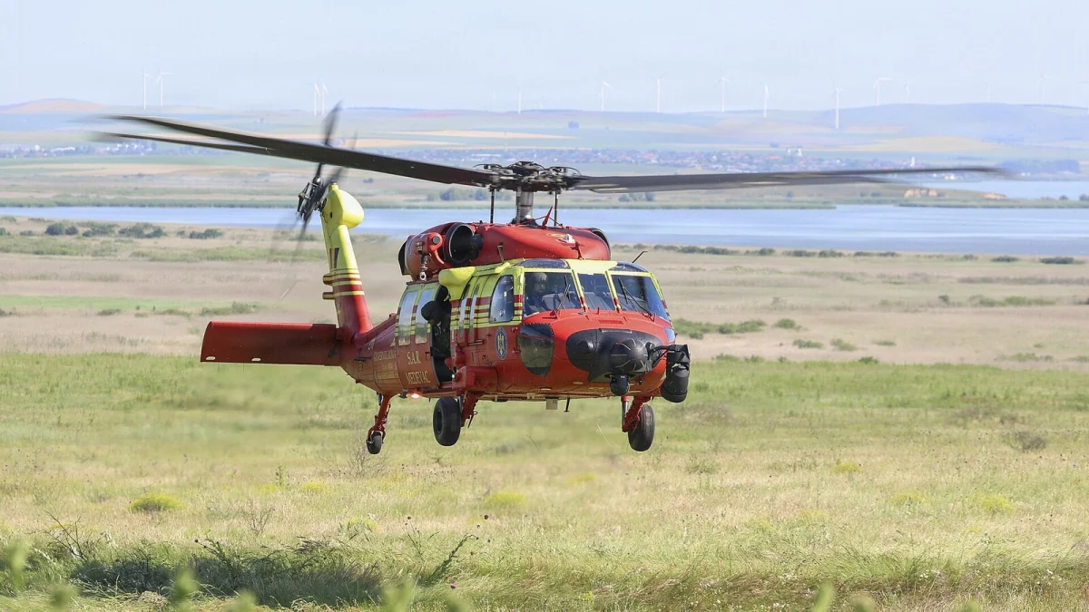 Elicopter Black Hawk roșu-galben al Inspectoratului General de Aviație, cu inscripția SMURD, în zbor jos deasupra unei pajiști din județul Tulcea (fotografie de arhivă, exercițiu din iunie 2026)