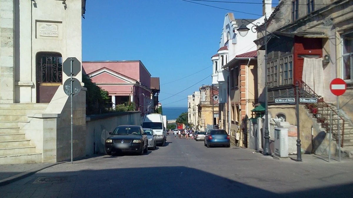 Strada Karatzali, la colțul cu strada Mircea cel Bătrân din Constanța, cu mașini parcate pe marginea străzii și marea în fundal (fotografie de arhivă, 2017)