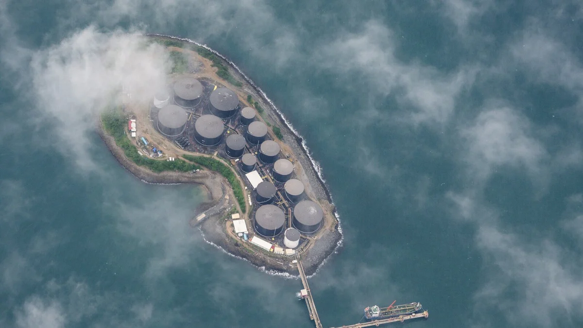 Rezervoare de țiței pe o insulă și un cheu de încărcare, văzute de sus (imagine ilustrativă, nu este Oil Terminal Constanța)
