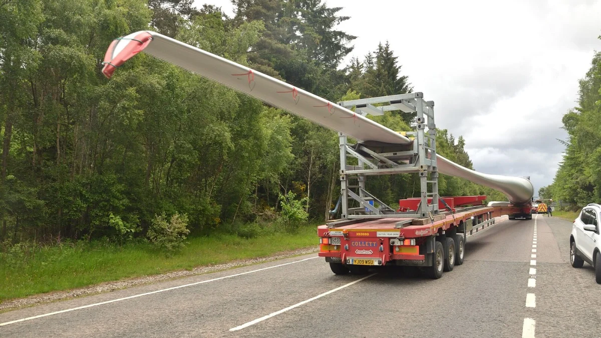 Camion care transportă o pală de turbină eoliană pe un drum național (imagine ilustrativă)