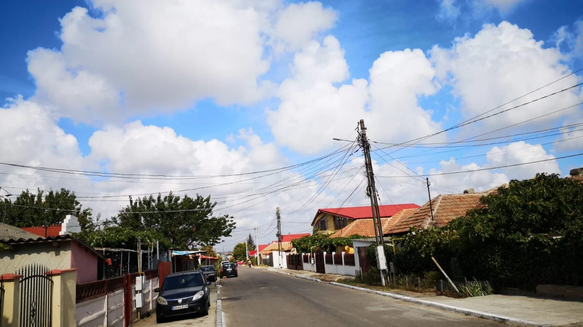 Stradă cu case și stâlpi de electricitate în orașul Ovidiu, județul Constanța