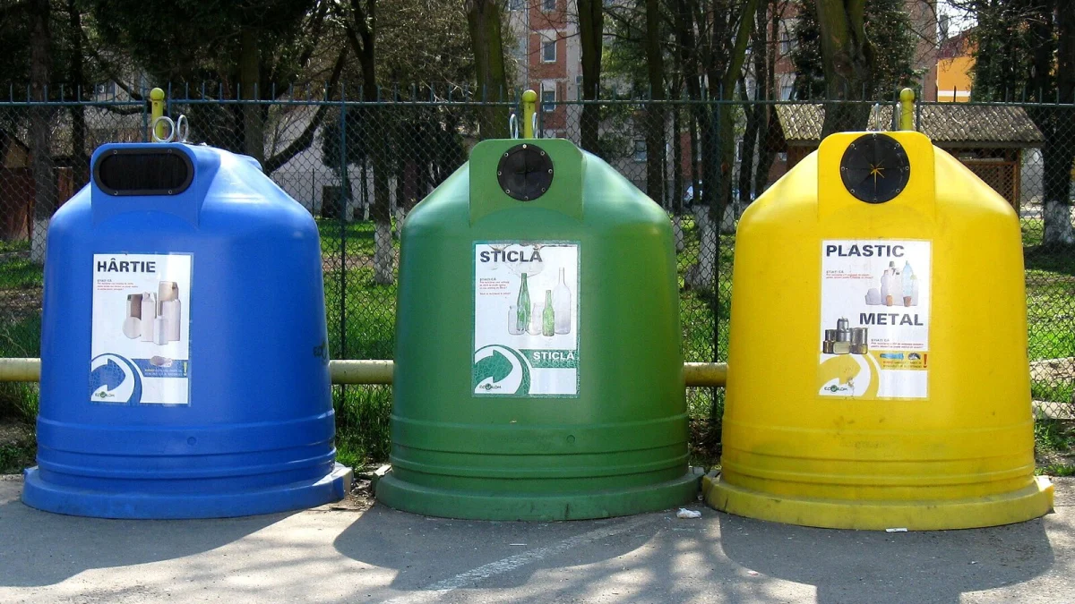Trei containere pentru colectare selectivă, albastru pentru hârtie, verde pentru sticlă și galben pentru plastic și metal, pe un trotuar (imagine ilustrativă, Deva, 2011, nu sunt platforme din Constanța)