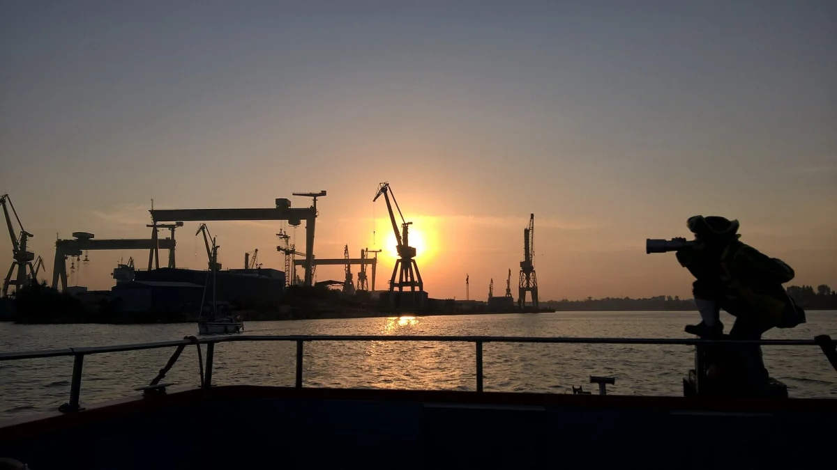 Macaralele șantierului naval din Mangalia, văzute de pe apă la apus