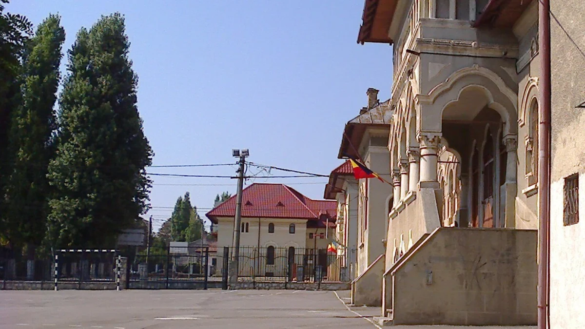 Curtea unei școli din Constanța construite în 1925 în stil neoromânesc, pe strada Nicolae Iorga, cu tricolorul la intrare (fotografie de arhivă, 2016, imagine ilustrativă)