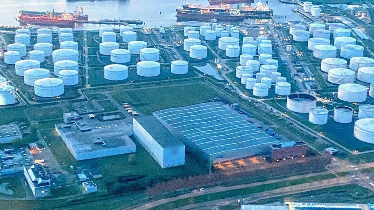 Parc de rezervoare albe pentru produse petroliere, lângă un chei cu două petroliere, văzut de sus (imagine ilustrativă, nu este Oil Terminal Constanța)