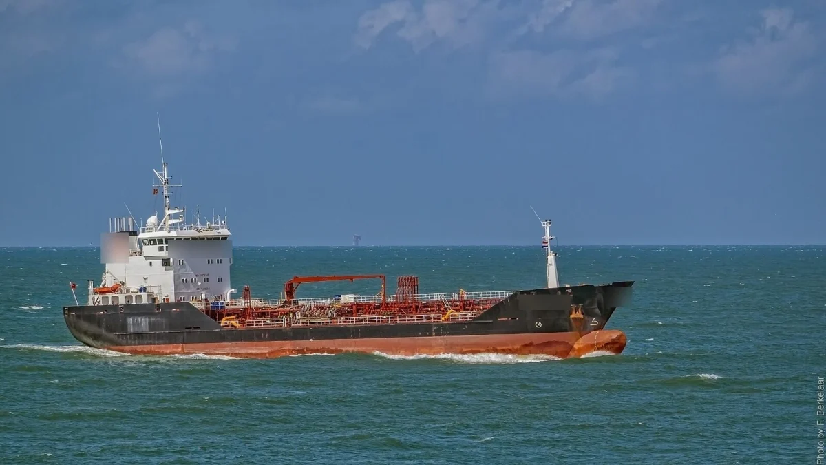 Navă-cisternă pentru produse chimice, cu corp negru și roșu, navigând pe o mare agitată, cu inscripțiile companiei estompate (imagine ilustrativă, nu este nava Wine Trader, Marea Nordului, 2016)