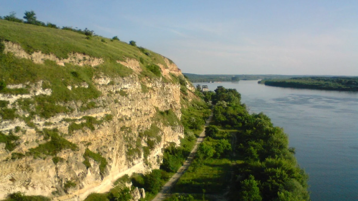Dunărea, văzută de pe un mal înalt, cu vegetație pe mal și insule în depărtare (imagine ilustrativă de arhivă, nu arată centrala)