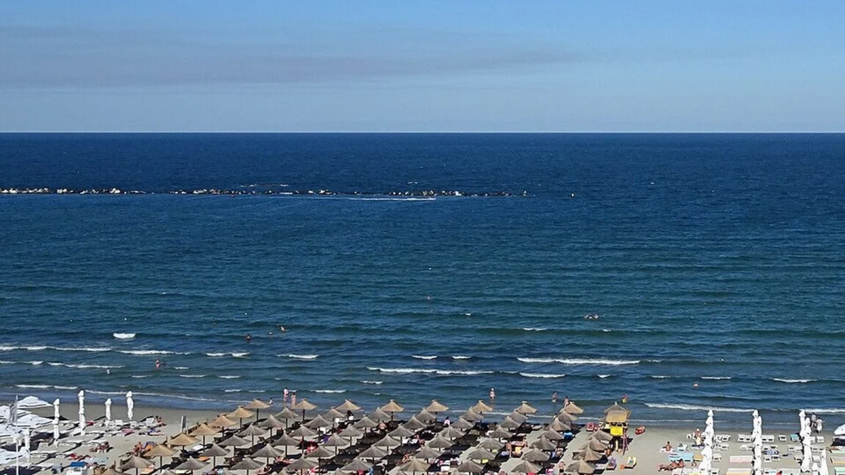 Plaja din Mamaia văzută de sus, cu umbrele de stuf și marea până la orizont (fotografie de arhivă din 2016)